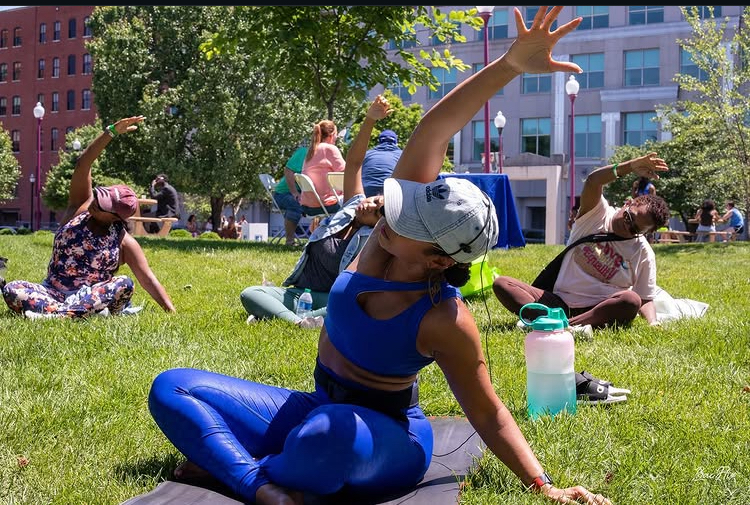 A wellness facilitator leading movement outdoors